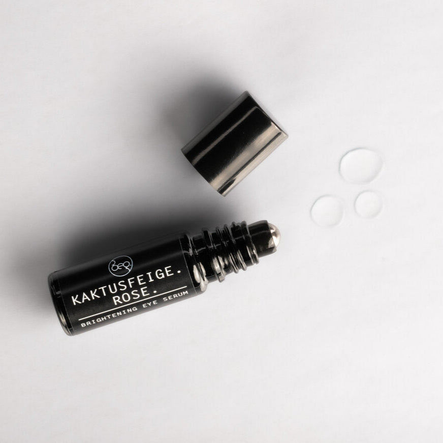 BRIGHTENING EYE SERUM ROSE - Augenserum Kaktusfeige mit Metall-Roll-on-Applikator, zeigt Textur und Anwendung für glatte Haut.